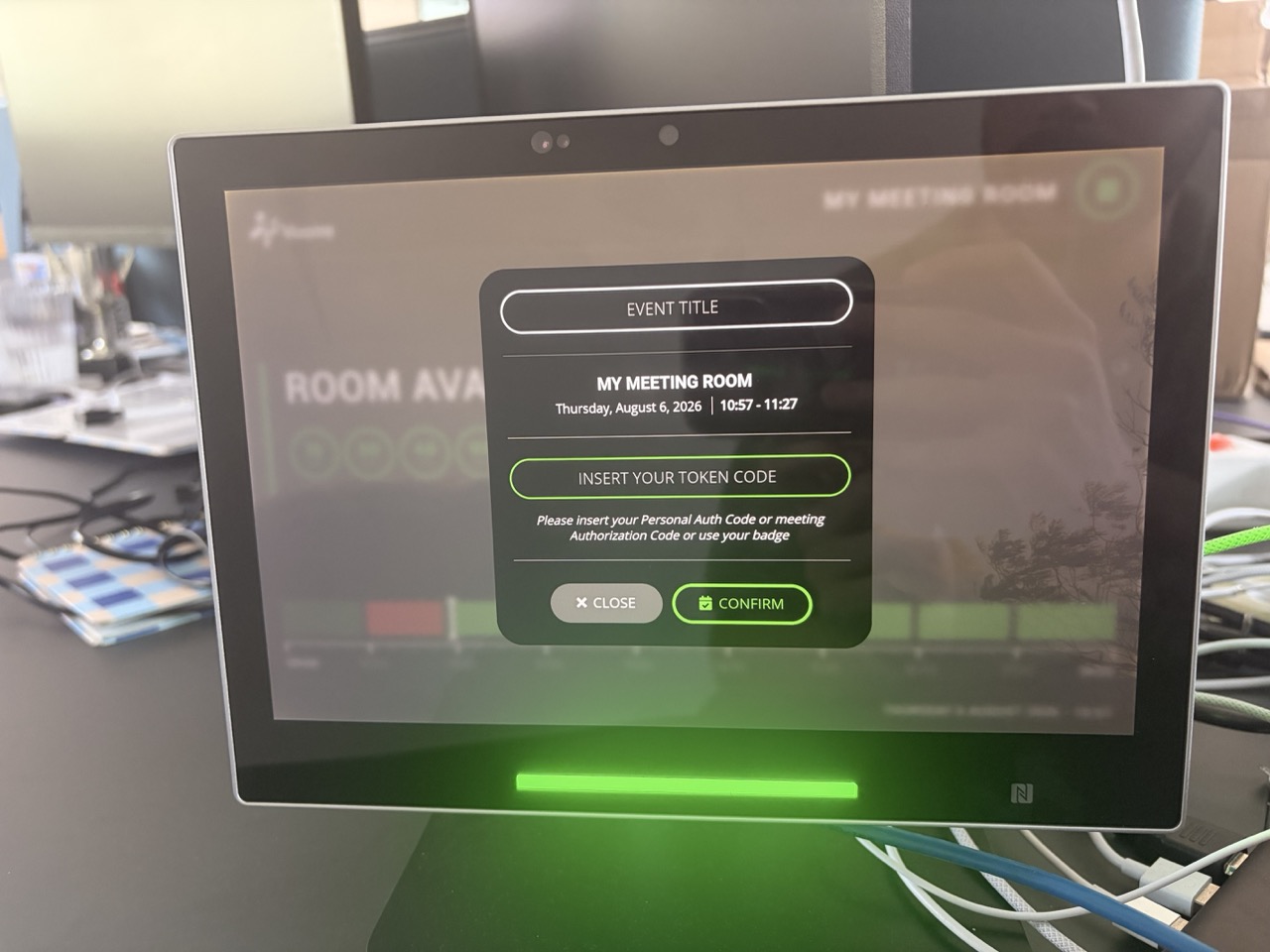 The confirmation dialog on the panel, with the event title field, the room and time summary, and the token code field